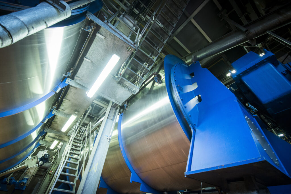 Industrial Machinery In Motion Within A Factory Setting.